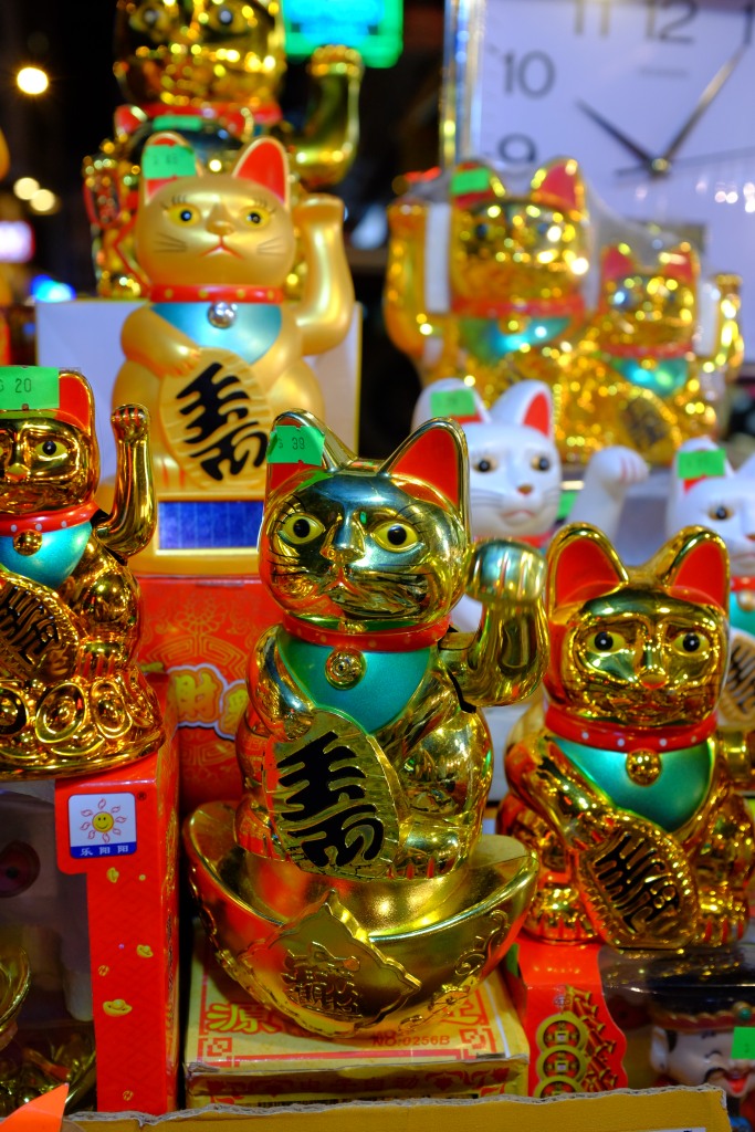 Goldene Katzen winken den Reichtum heran.